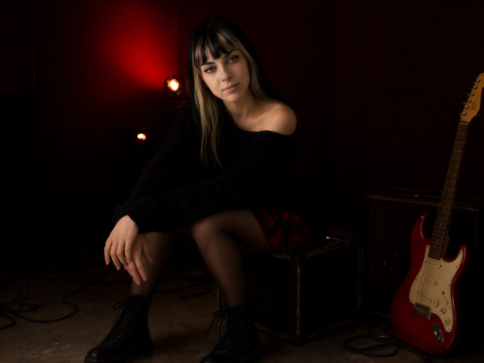 ZYRRA sitting on a guitar amp in a rehearsal room